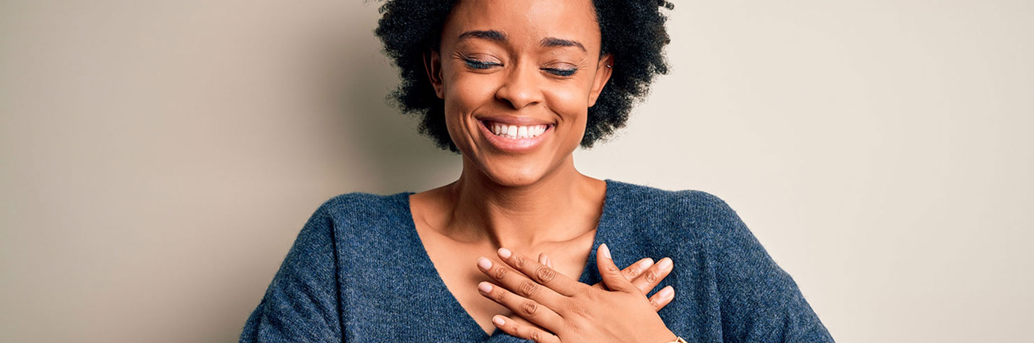 Woman smiling with hands over heart